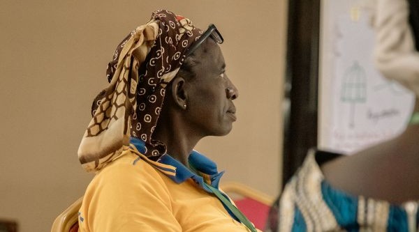 Kobieta siedzi w sali szkoleniowej.