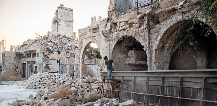 Młody chłopak w ruinach Alleppo