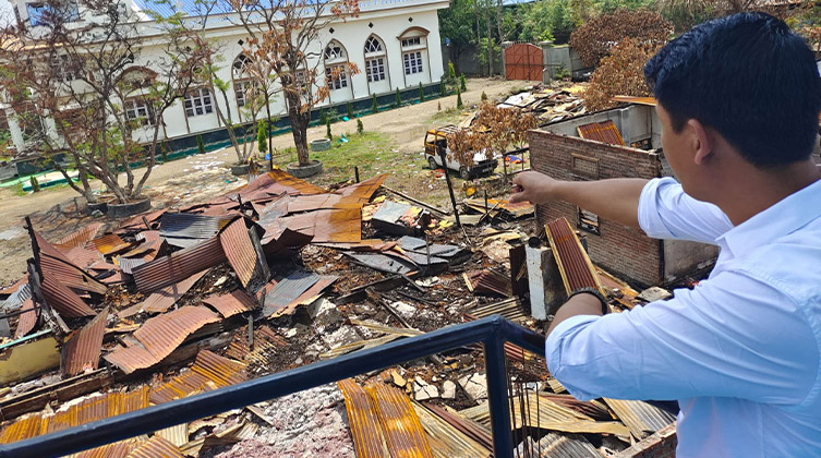 Chrześcijanin przygląda się ruinom swojego domu i biura