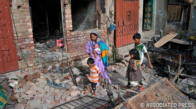 Chrześcijanki z dziećmi na gruzach domu zniszczonego przez ekstremistów w Jaranwala (prowincja Pendżab, Pakistan Wschodni)